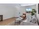 Bright living room with wood flooring, a large window, and a comfortable sofa, creating a welcoming space at 1612 E Desert Rose Trl, San Tan Valley, AZ 85143