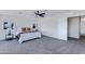 Spacious primary bedroom showcasing plush bedding, a ceiling fan, and a doorway to another room at 1612 E Desert Rose Trl, San Tan Valley, AZ 85143