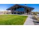 Community amenity building featuring an open-air design, stone accents, and a large grassy area at 16928 W Jenan Rd, Surprise, AZ 85388