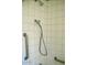 Tiled shower featuring handrails and a showerhead at 1837 W Roma Ave, Phoenix, AZ 85015