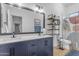 Stylish bathroom featuring a blue vanity, large mirror, and open shelving next to the toilet at 18437 E Celtic Manor Dr, Queen Creek, AZ 85142