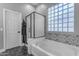 Bathroom featuring a soaking tub, a glass block window, and a black framed shower at 18437 E Celtic Manor Dr, Queen Creek, AZ 85142