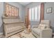Cozy Bedroom with crib, chair, rocking horse, and whimsical decor, perfect for a new baby at 18437 E Celtic Manor Dr, Queen Creek, AZ 85142
