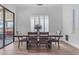 Bright dining area featuring a rustic wooden table, modern chairs, and sliding glass doors to the patio at 18437 E Celtic Manor Dr, Queen Creek, AZ 85142