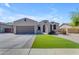 Beautiful single-story home with well-maintained desert landscaping, complemented by a lush green lawn at 18437 E Celtic Manor Dr, Queen Creek, AZ 85142