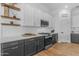 Contemporary kitchen with white subway tile backsplash, two-tone cabinets, and modern stainless steel appliances at 18437 E Celtic Manor Dr, Queen Creek, AZ 85142