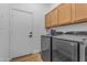Convenient laundry room with updated machines, storage cabinets, and easy access door at 18437 E Celtic Manor Dr, Queen Creek, AZ 85142