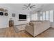 Bright living room featuring wood-look floors, large sectional, and plantation shutters for a modern and airy feel at 18437 E Celtic Manor Dr, Queen Creek, AZ 85142