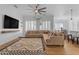 Spacious living room featuring hardwood floors, a large sectional, and ample natural light at 18437 E Celtic Manor Dr, Queen Creek, AZ 85142
