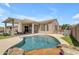 Serene backyard oasis with a sparkling pool, covered patio, and meticulously landscaped surroundings at 18437 E Celtic Manor Dr, Queen Creek, AZ 85142