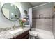 Updated bathroom features a granite countertop, modern fixtures, and stylish tile work in the shower and bath at 18643 N 73Rd Ave, Glendale, AZ 85308