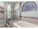 Bathroom with a soaking tub and glass shower, featuring modern fixtures and tile surround at 18643 N 73Rd Ave, Glendale, AZ 85308