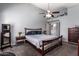 Serene bedroom with plush carpeting, ceiling fan, and a decorative bed frame with elegant bedside tables at 18643 N 73Rd Ave, Glendale, AZ 85308