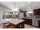 Bright kitchen with granite island, stainless steel appliances, dark wood cabinets and breakfast nook at 18643 N 73Rd Ave, Glendale, AZ 85308