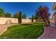 Backyard view showing the green grass, rock landscaping, and block wall at 1865 S Morrison Ln, Gilbert, AZ 85295