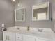 Elegant bathroom with double sinks, white cabinetry, modern fixtures, and dual decorative mirrors at 1865 S Morrison Ln, Gilbert, AZ 85295