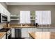 Kitchen with white cabinets, granite countertops, stainless appliances, and practical shelving at 1865 S Morrison Ln, Gilbert, AZ 85295
