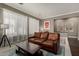 Cozy living room with a brown leather sofa and bright natural light at 1865 S Morrison Ln, Gilbert, AZ 85295