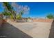 Backyard with brick building, tree, gravel, and paved area at 1919 W Fairmount Ave, Phoenix, AZ 85015