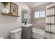 Bathroom features sink with gray vanity, toilet, mirror, shower, and tub with window at 1919 W Fairmount Ave, Phoenix, AZ 85015