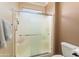 Tiled bathroom features glass shower doors and neutral wall paint at 20473 N Desert Sage Ln, Surprise, AZ 85374