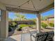 Covered outdoor patio with seating that looks out to a beautifully landscaped backyard with artificial turf at 22026 N 28Th Pl, Phoenix, AZ 85050
