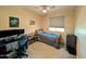 A cozy bedroom features a ceiling fan, window with blinds, and gaming setup for comfortable living at 22026 N 28Th Pl, Phoenix, AZ 85050