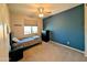 This cozy bedroom is equipped with a ceiling fan, window with blinds, and a navy accent wall at 22026 N 28Th Pl, Phoenix, AZ 85050