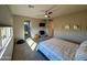 A carpeted main bedroom features a ceiling fan, neutral walls, a TV, a walk-in bathroom, and natural light at 22026 N 28Th Pl, Phoenix, AZ 85050
