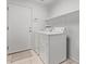 A well-lit laundry room featuring a modern washer and dryer, with shelving above at 2233 S Nielson St, Gilbert, AZ 85295