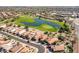 Aerial view of the community showcasing well-maintained homes, a golf course, and a serene pond at 22940 W Desert Bloom St, Buckeye, AZ 85326