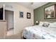 Relaxing bedroom featuring an ocean-themed decor, a queen bed, dresser, and tiled doorway at 22940 W Desert Bloom St, Buckeye, AZ 85326