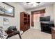 Cozy bedroom with a ceiling fan, large bookcase, TV, and a comfortable chair at 22940 W Desert Bloom St, Buckeye, AZ 85326