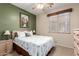 Serene bedroom with a green accent wall, seashell themed bedding, and wooden nightstands at 22940 W Desert Bloom St, Buckeye, AZ 85326