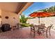 Covered patio with chairs and table set, overlooking a manicured lawn and beautiful scenery at 22940 W Desert Bloom St, Buckeye, AZ 85326