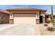 Home exterior featuring a wide driveway and low-maintenance desert landscaping at 22940 W Desert Bloom St, Buckeye, AZ 85326