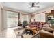 Cozy living room with a ceiling fan, comfortable seating, and view to the outside patio at 22940 W Desert Bloom St, Buckeye, AZ 85326