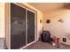 Outdoor patio with brick flooring, screen door, and a small covered table at 22940 W Desert Bloom St, Buckeye, AZ 85326