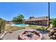 Backyard oasis featuring pool, fire pit, and manicured lawn perfect for entertaining at 2322 E Dolphin Ave, Mesa, AZ 85204