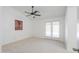 Bright bedroom features neutral carpet, ceiling fan, and access to outdoor patio at 2322 E Dolphin Ave, Mesa, AZ 85204