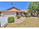 Charming single-story home featuring a well-manicured lawn, mature landscaping, and a two-car garage at 2322 E Dolphin Ave, Mesa, AZ 85204
