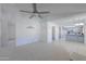 Bright living room featuring a ceiling fan, neutral carpet, and an open floor plan leading to the kitchen at 2322 E Dolphin Ave, Mesa, AZ 85204