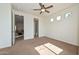 Sun-filled bedroom featuring neutral carpet, a ceiling fan, and several windows for natural light at 248 S 167Th Dr, Goodyear, AZ 85338