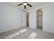 Bright bedroom features neutral carpeting, an open walk-in closet, and modern ceiling fan at 248 S 167Th Dr, Goodyear, AZ 85338