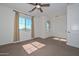 Bright bedroom with a ceiling fan, plush carpet, and a large window for natural light at 248 S 167Th Dr, Goodyear, AZ 85338