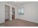 Cozy bedroom with carpet, ceiling fan, and a window, next to the bathroom at 248 S 167Th Dr, Goodyear, AZ 85338