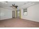Spacious main bedroom with a tray ceiling, fan, balcony access, and plenty of natural light at 248 S 167Th Dr, Goodyear, AZ 85338
