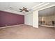 Large main bedroom featuring a tray ceiling, fan, adjoining bathroom, and neutral carpeting at 248 S 167Th Dr, Goodyear, AZ 85338