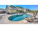 Backyard pool with rock features, next to a patio on a sunny day at 248 S 167Th Dr, Goodyear, AZ 85338