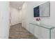 Hallway with light-colored walls, wood-look flooring, glass console table, and decorative artwork provides a welcoming entrance at 2511 W Queen Creek Rd # 262, Chandler, AZ 85248